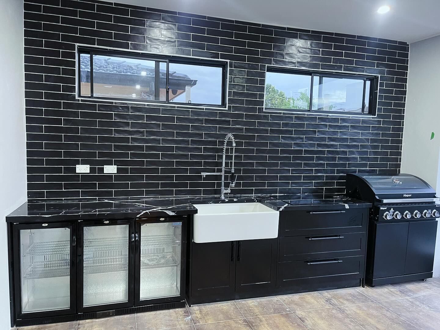 Kitchenette with black subway tiles and timber-look flooring